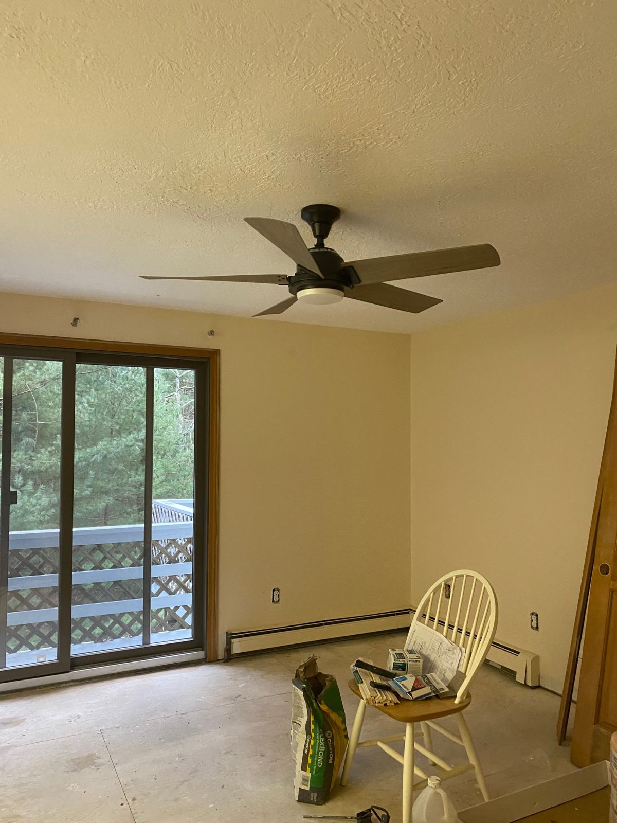 Five-blade ceiling fan with an LED light kit installed in a bedroom